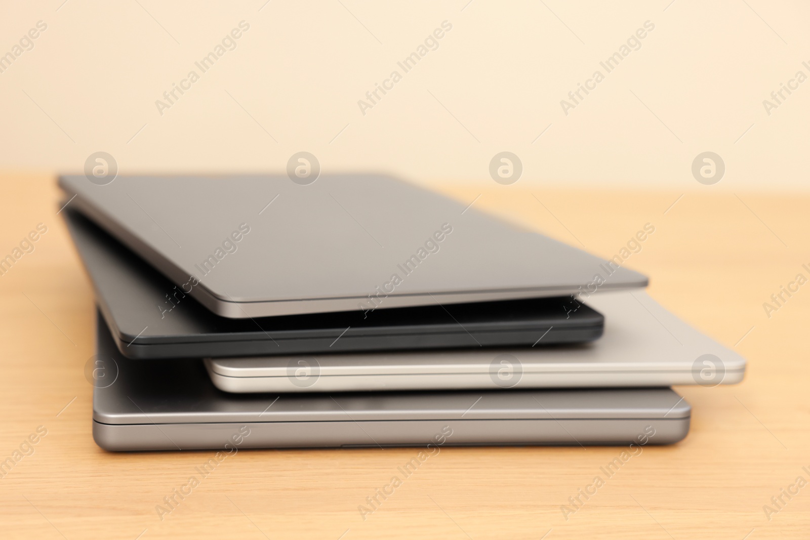 Photo of Different modern laptops on wooden table, closeup