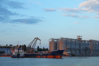 Cargo ship with big crane at industrial docks