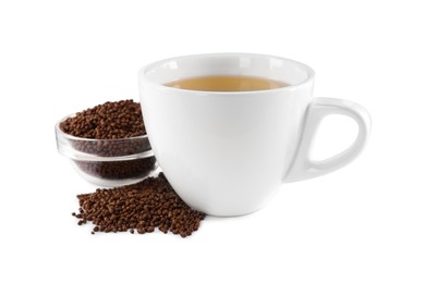 Cup of aromatic buckwheat tea and granules on white background