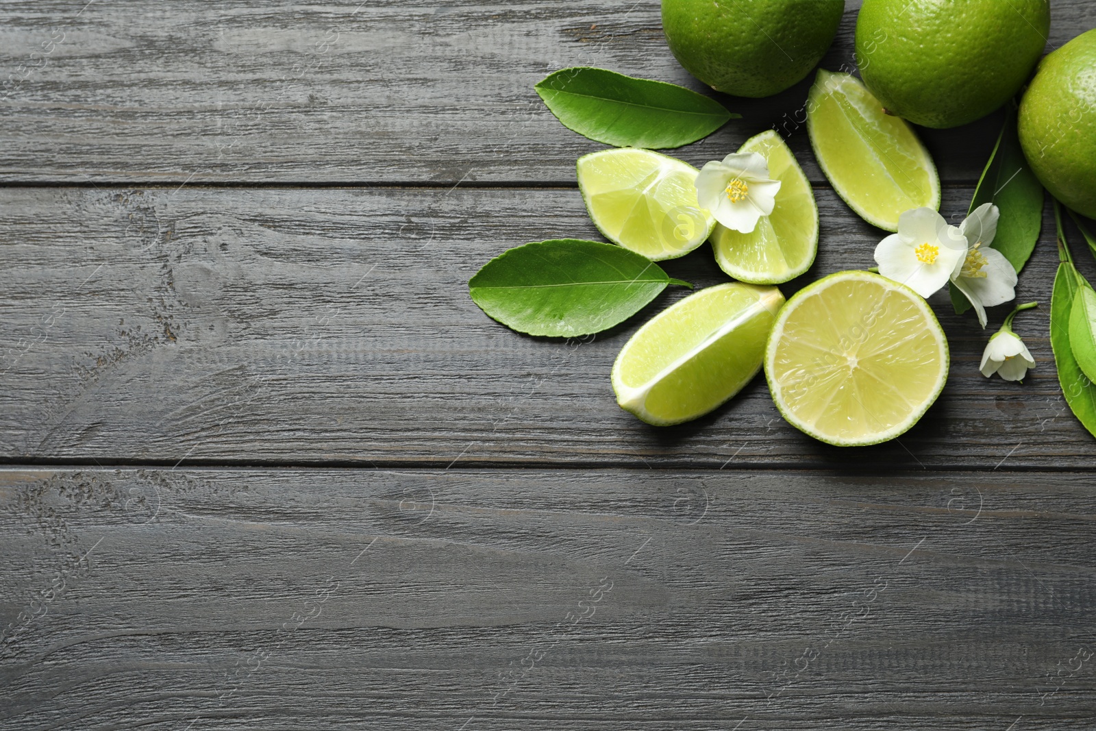 Photo of Composition with fresh ripe limes on wooden background, top view