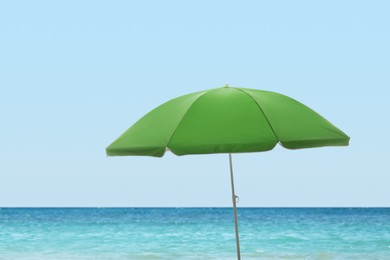 Image of Open big beach umbrella near sea on sunny day 