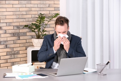 Ill businessman suffering from cough in office