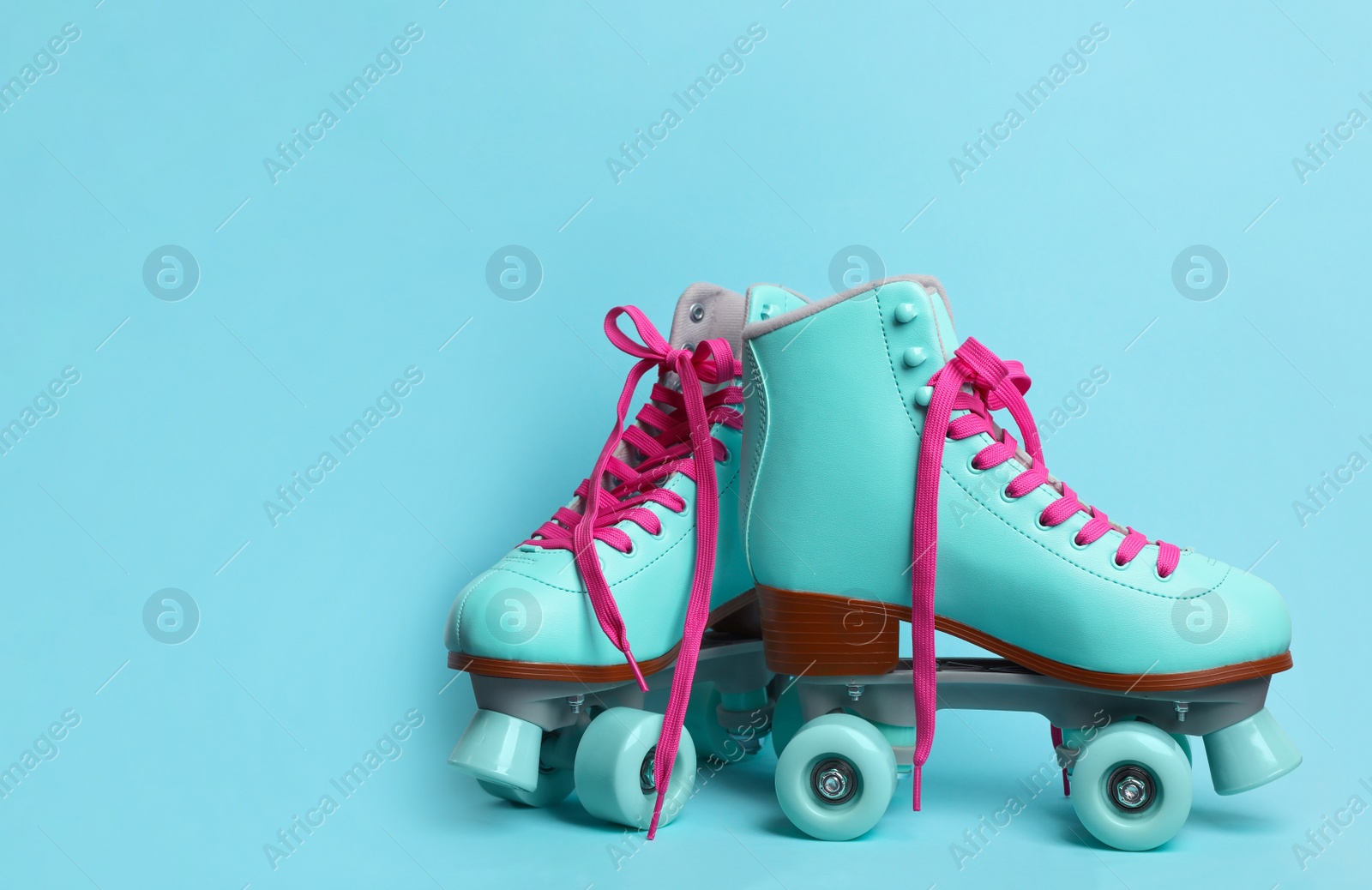 Photo of Pair of stylish quad roller skates on color background. Space for text