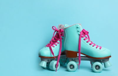 Photo of Pair of stylish quad roller skates on color background. Space for text