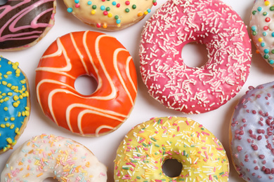 Photo of Delicious glazed donuts on white background, flat lay