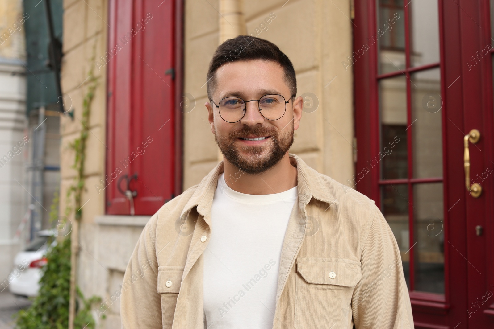 Photo of Portrait of handsome bearded man in glasses outdoors