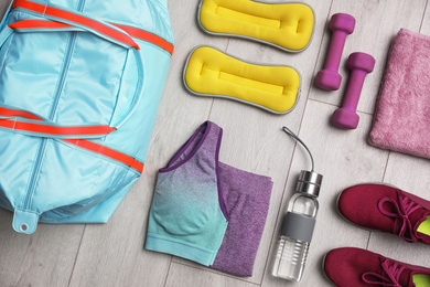 Flat lay composition with sports bag on wooden background