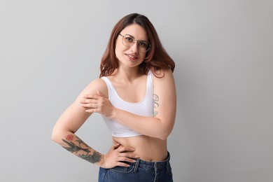 Portrait of beautiful tattooed woman on gray background