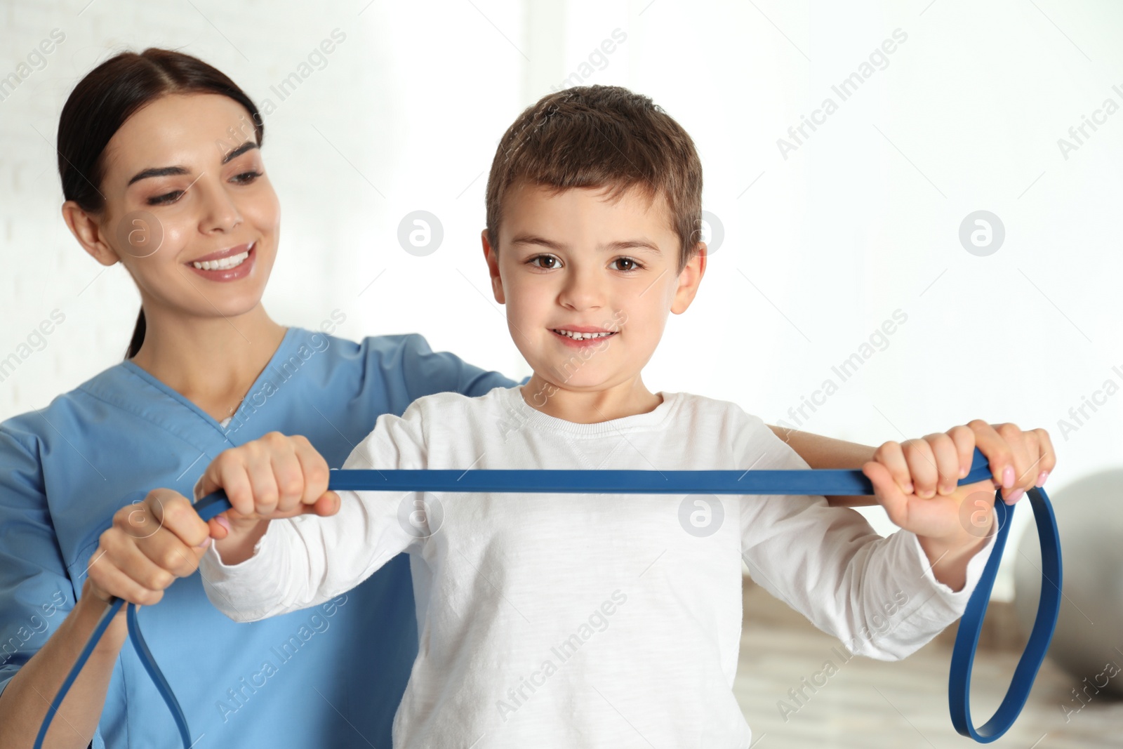 Photo of Orthopedist working with little boy in hospital gym