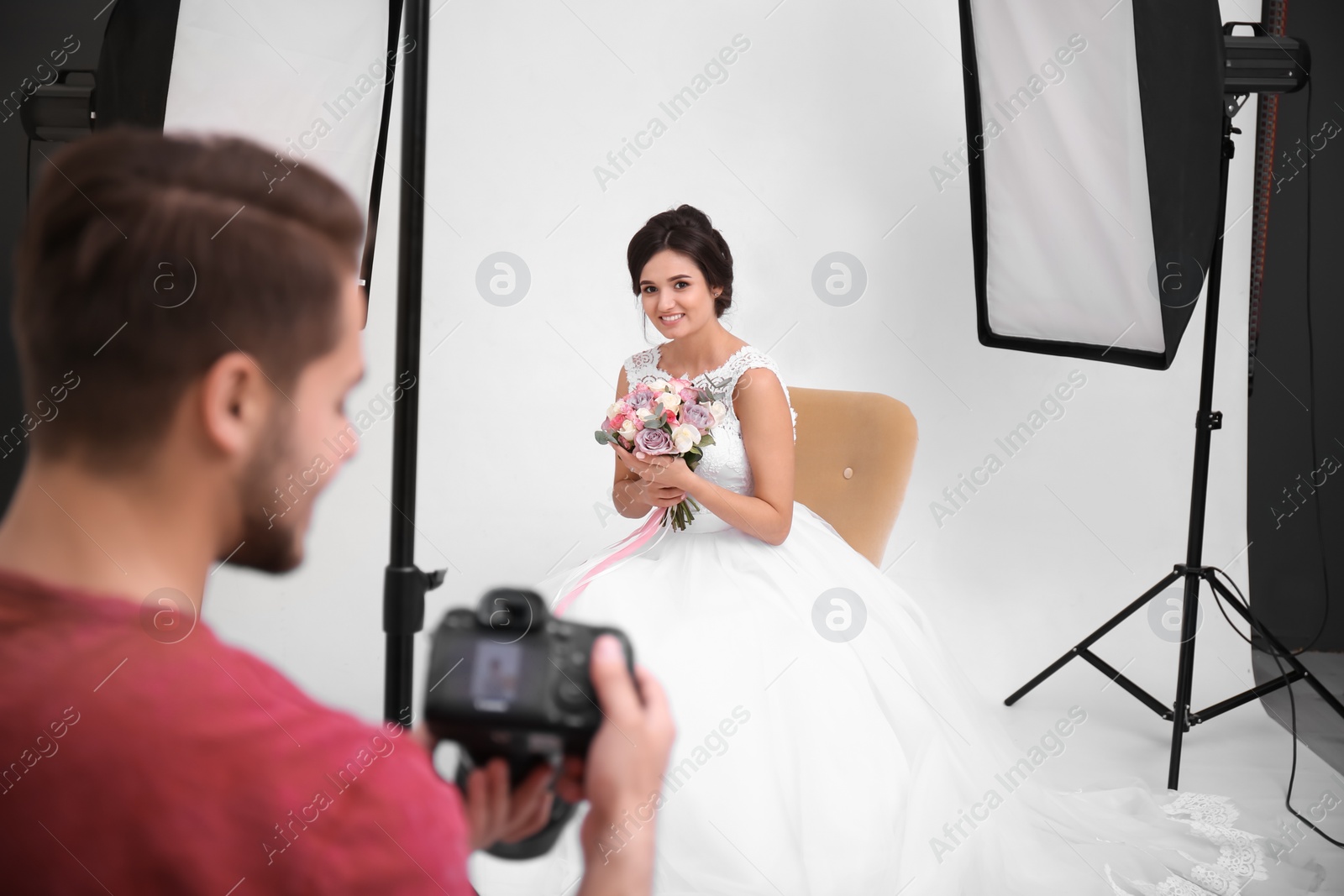 Photo of Professional photographer taking photo of beautiful bride in studio