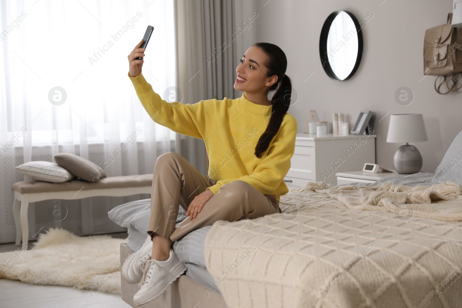 Photo of Young woman taking selfie at home in morning