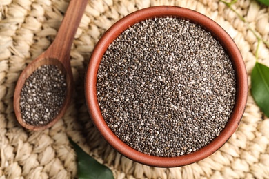 Photo of Bowl and spoon with chia seeds on wicker stand, flat lay