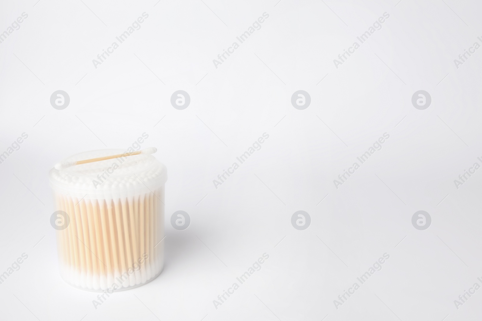 Photo of New cotton buds in container on white background. Space for text