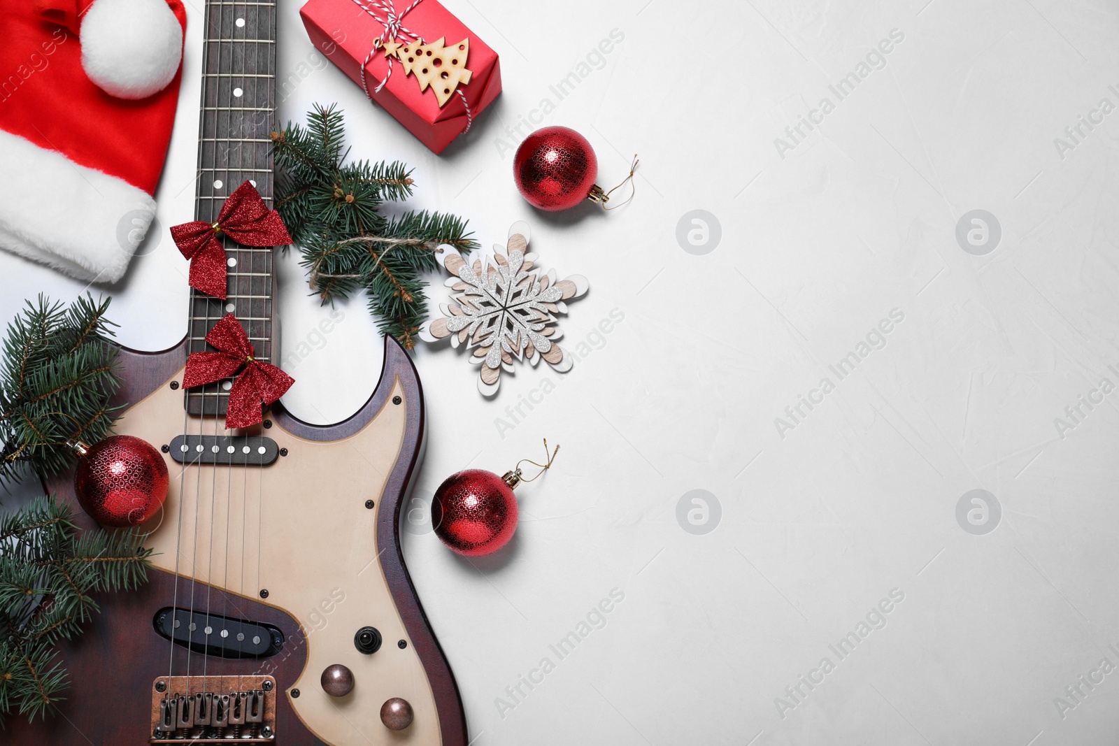 Photo of Guitar and festive decorations on white background, flat lay with space for text. Christmas music