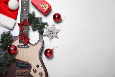 Photo of Guitar and festive decorations on white background, flat lay with space for text. Christmas music