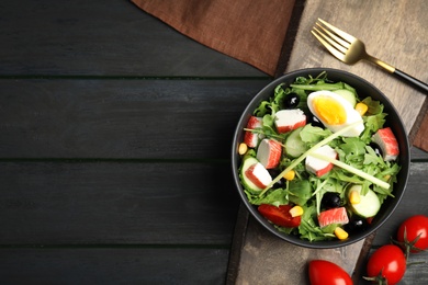 Tasty crab stick salad served on grey wooden table, flat lay. Space for text