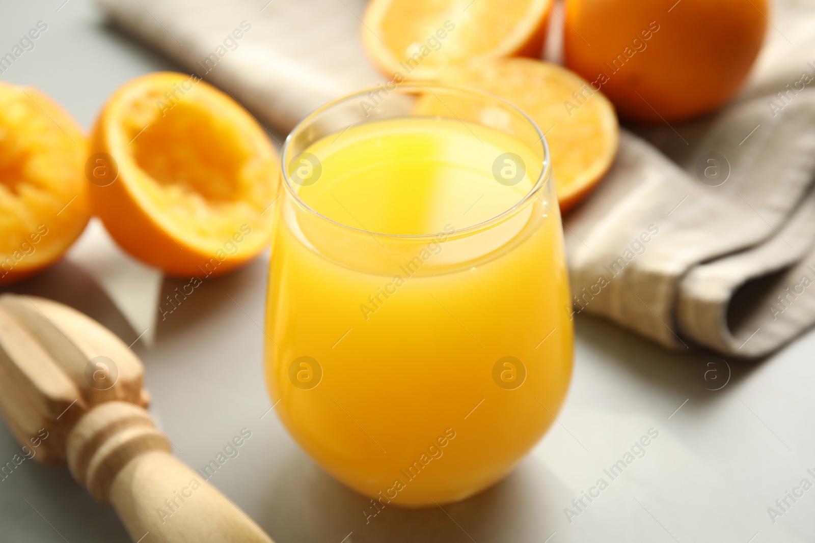 Photo of Freshly made juice, oranges and reamer on table, closeup