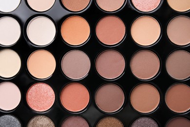 Photo of Beautiful eyeshadow palette as background, top view. Professional cosmetic product
