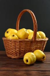 Photo of Basket with delicious ripe quinces on wooden table