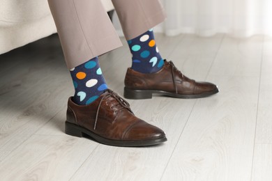 Man wearing stylish shoes and colorful socks indoors, closeup