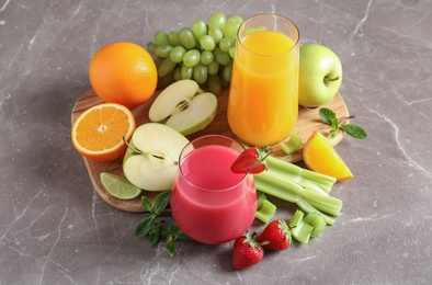 Photo of Glasses with different juices and fresh fruits on table