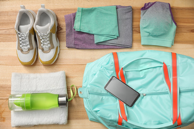 Flat lay composition with sports bag on wooden background