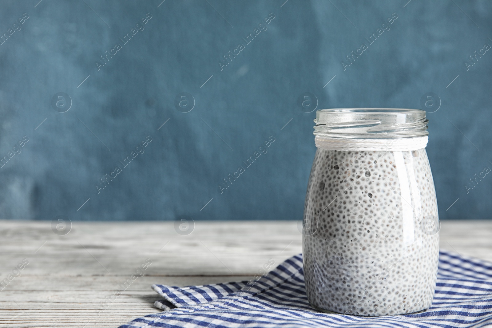 Photo of Jar of tasty chia seed pudding on table. Space for text