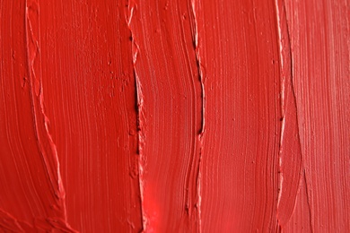 Photo of Red lipstick smears as background, closeup. Cosmetic product