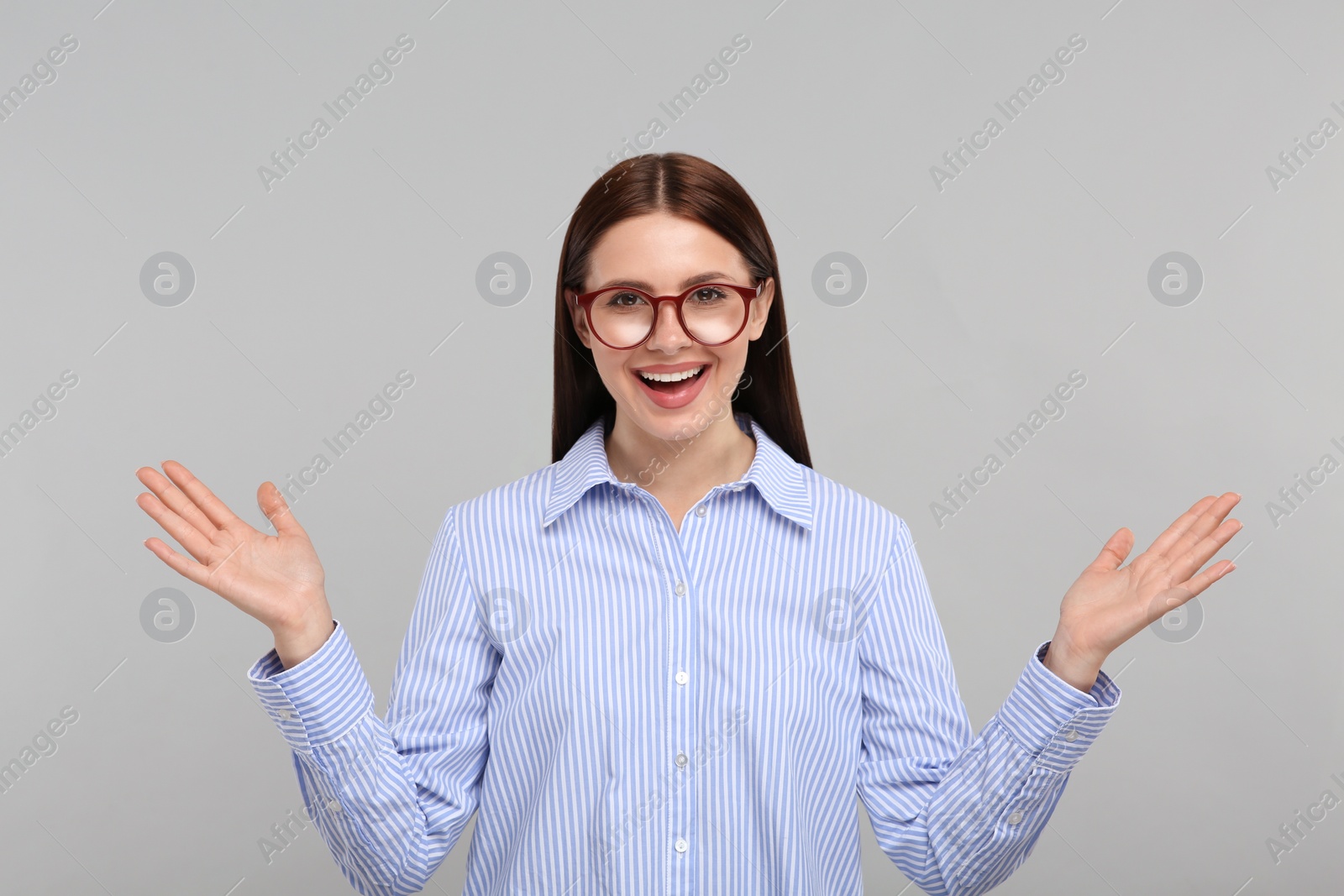 Photo of Portrait of emotional woman in stylish eyeglasses on grey background