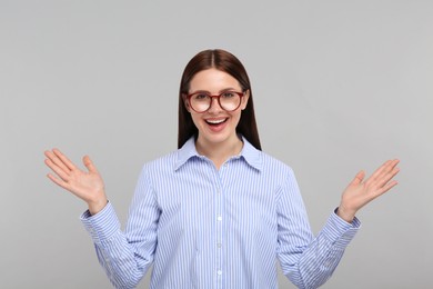 Portrait of emotional woman in stylish eyeglasses on grey background