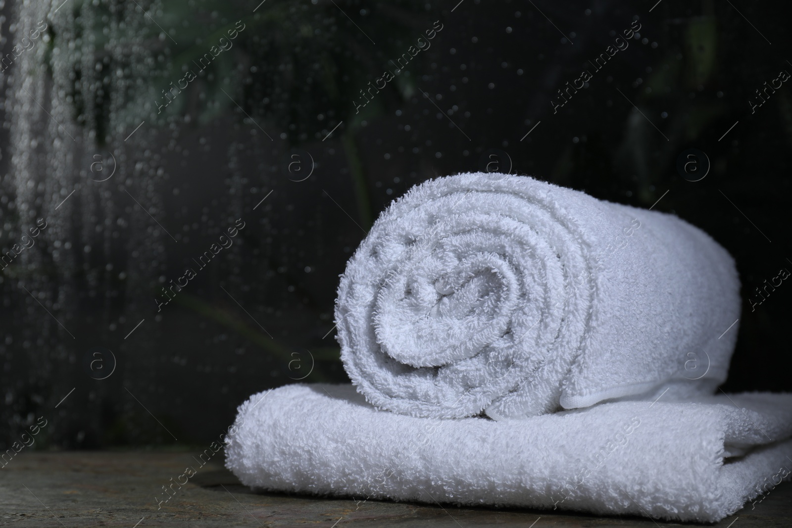 Photo of White terry towels on table in bathroom, space for text