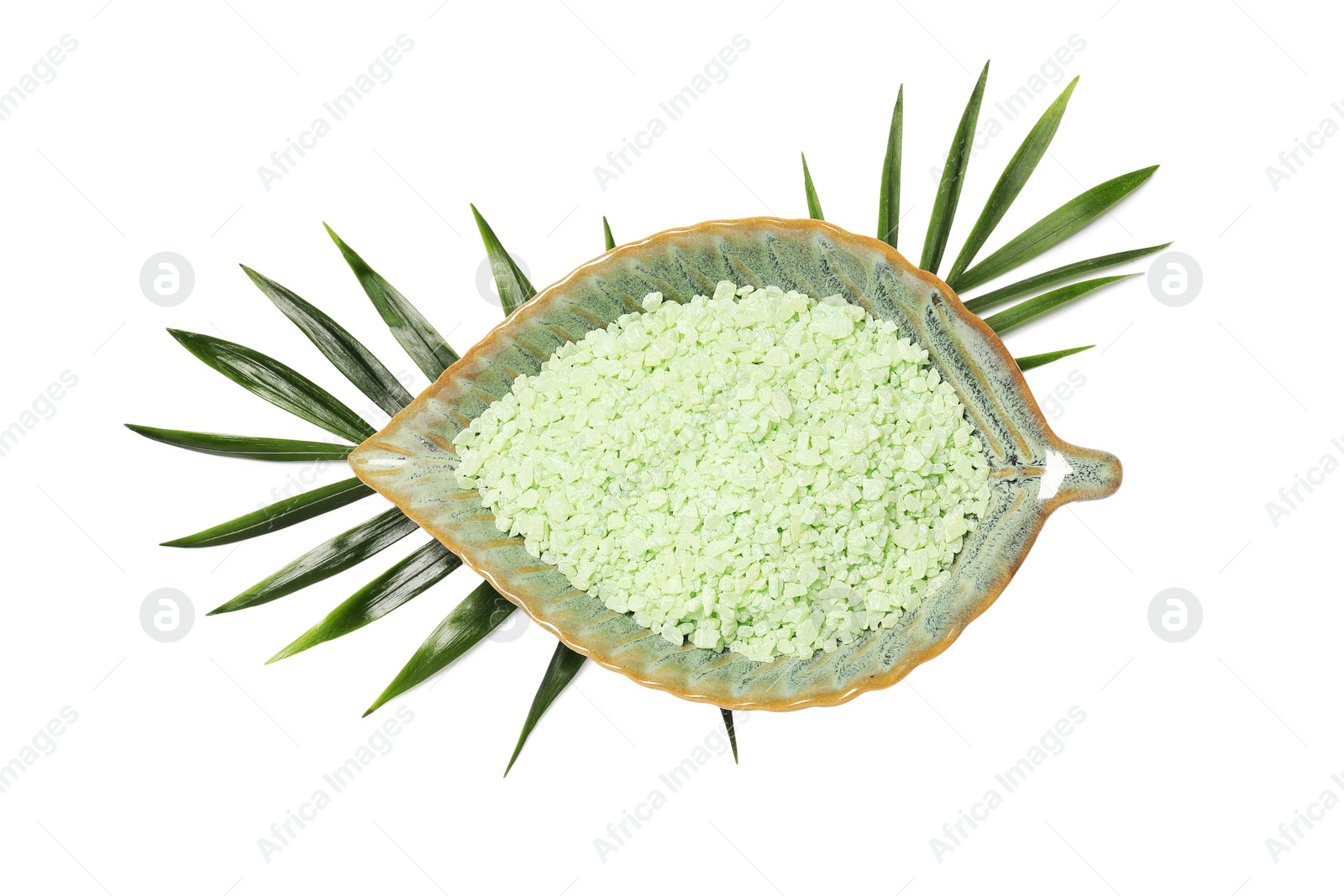 Photo of Green sea salt in bowl and palm leaves isolated on white, top view