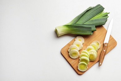 Photo of Flat lay composition with fresh raw leek on light table, space for text. Ripe onion