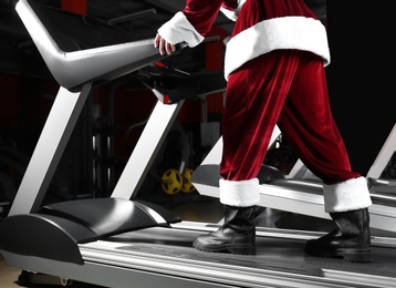 Authentic Santa Claus training on treadmill in modern gym, closeup