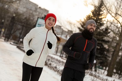 Happy people running in winter park. Outdoors sports exercises