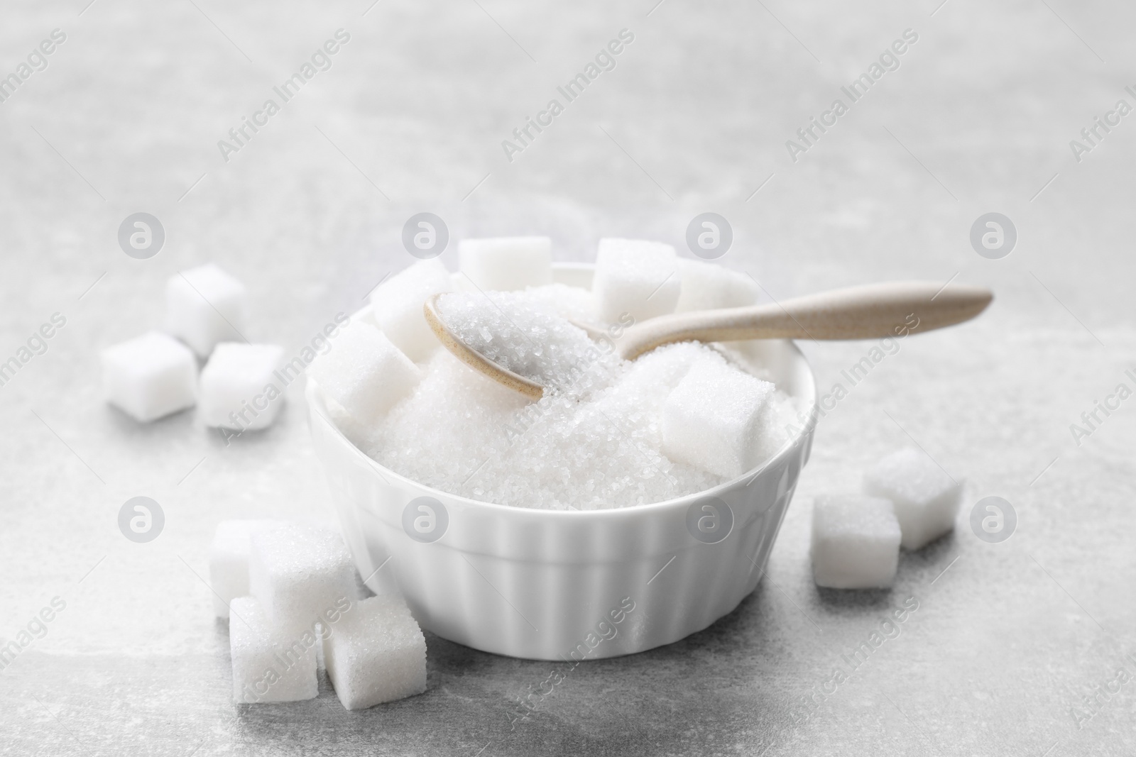 Photo of Different types of white sugar on grey table