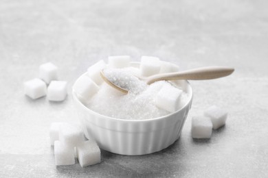 Different types of white sugar on grey table