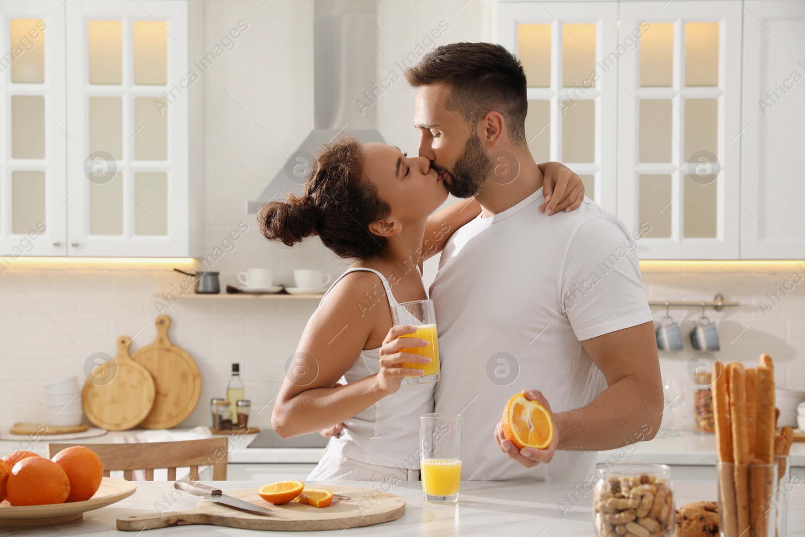 Photo of Lovely couple enjoying time together during breakfast at table in kitchen