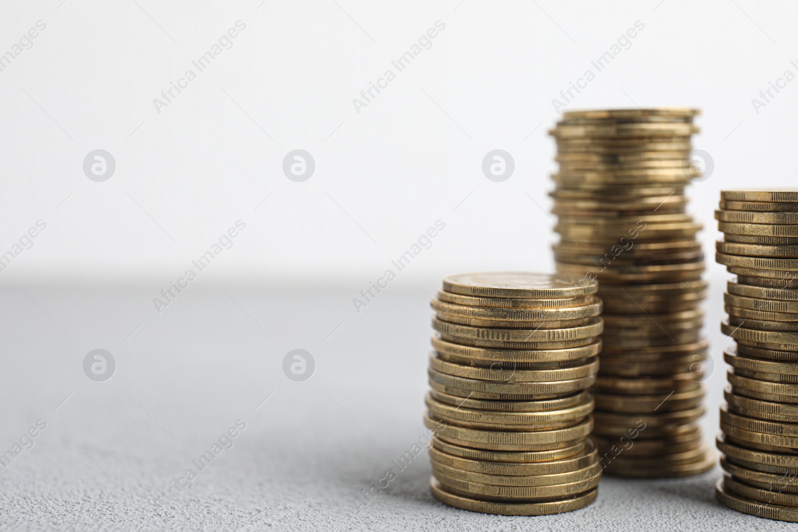 Photo of Many coins stacked on white table, space for text