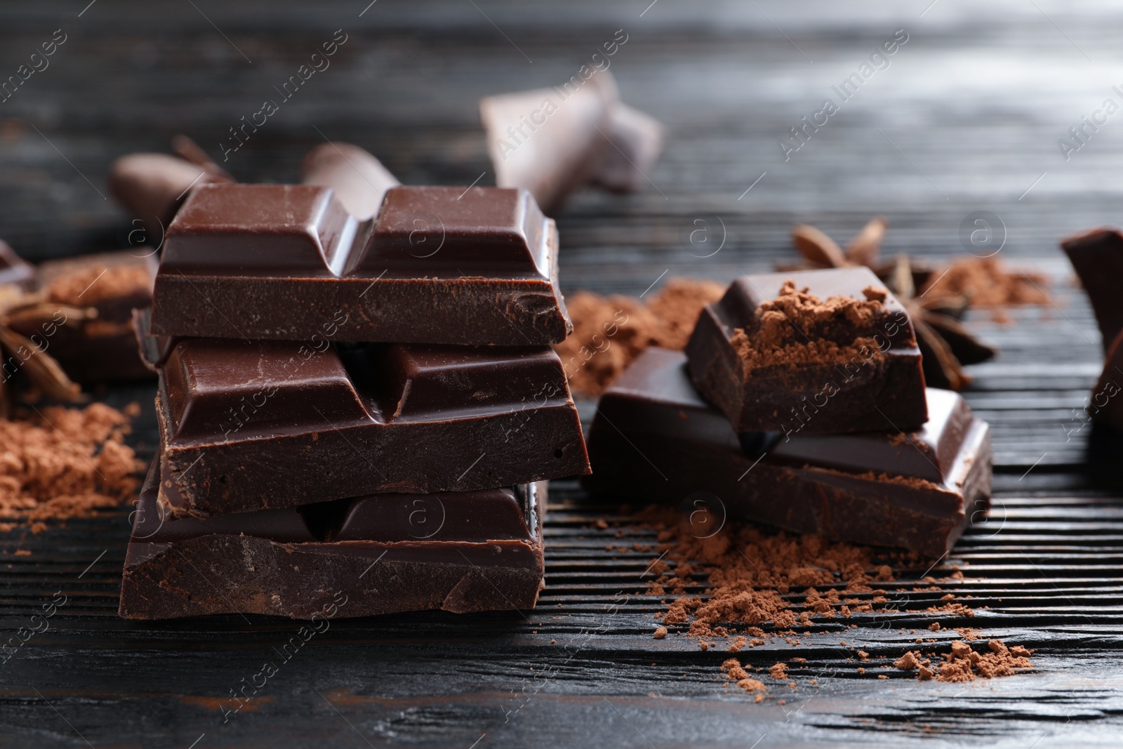 Photo of Pieces of black chocolate on wooden table