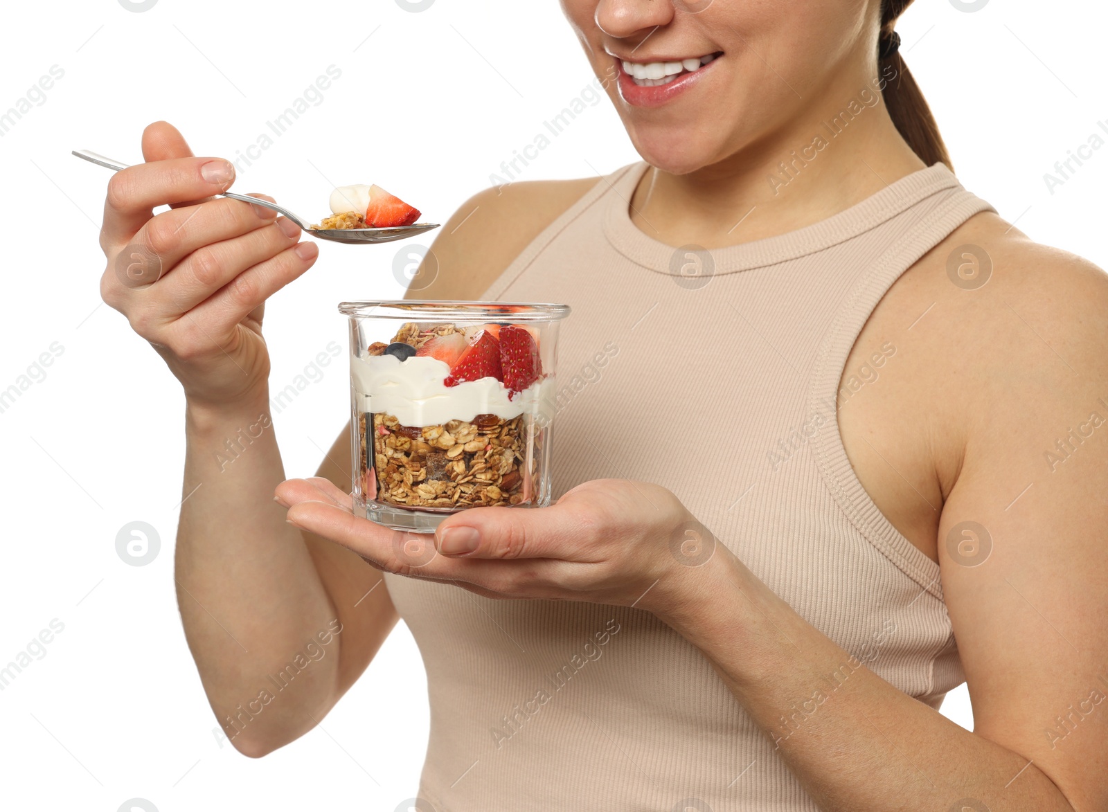 Photo of Happy woman eating tasty granola with fresh berries and yogurt on white background, closeup