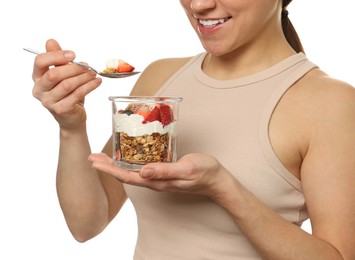Photo of Happy woman eating tasty granola with fresh berries and yogurt on white background, closeup