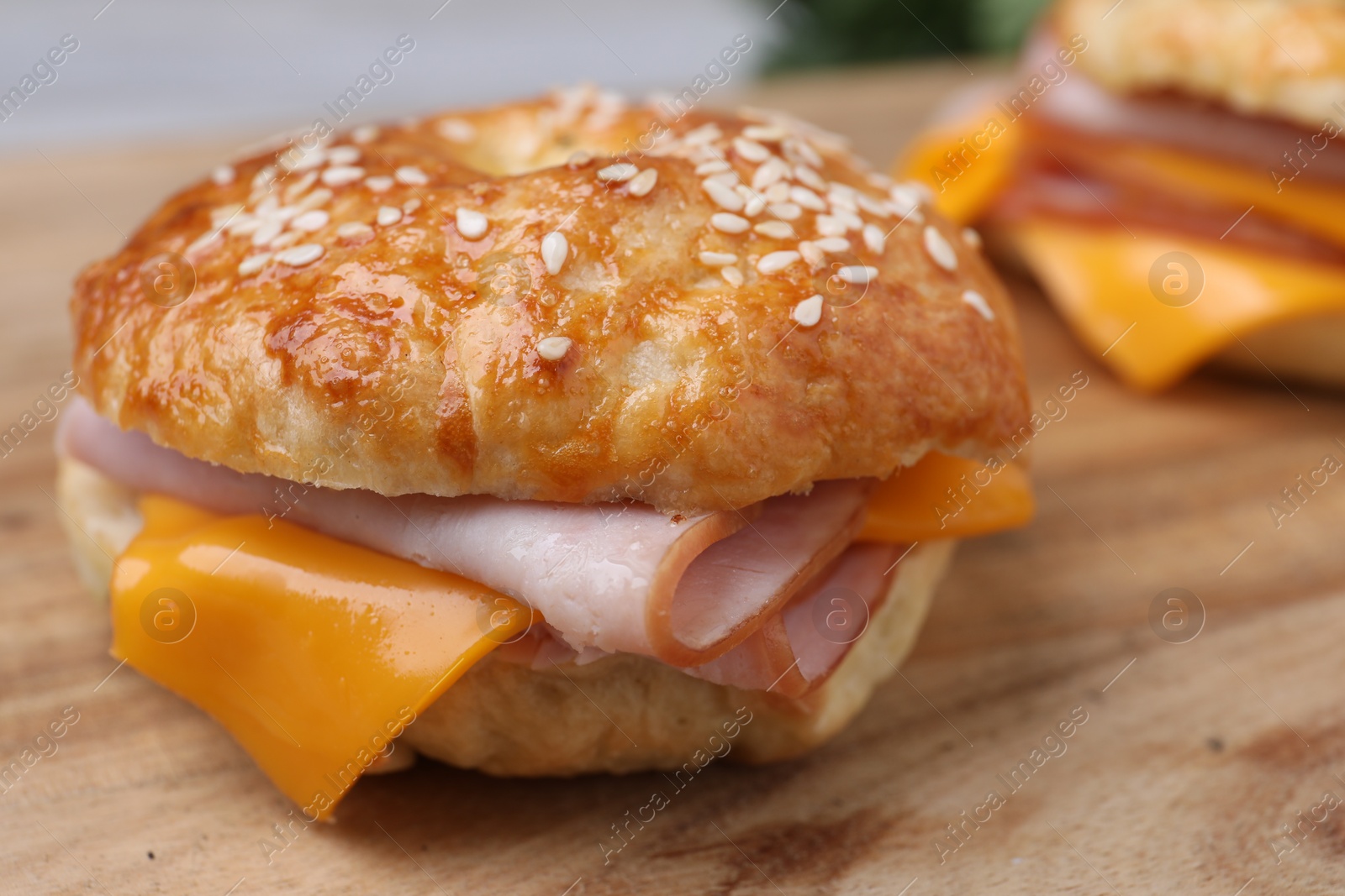 Delicious bagels with ham and cheese on wooden table, closeup Photo of Delicious bagels with ham and cheese on wooden table, closeup