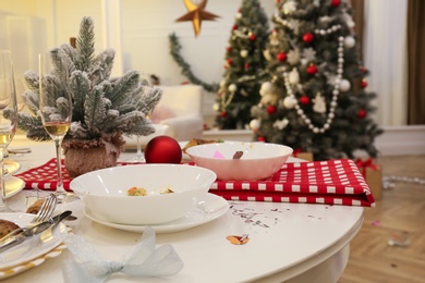 Photo of Dirty dishes on white table in room. Mess after new year party