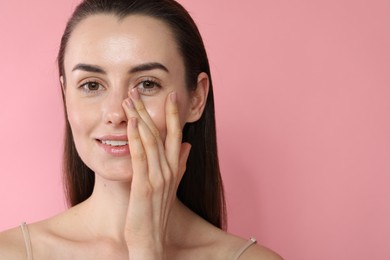 Portrait of beautiful young woman on pink background. Space for text