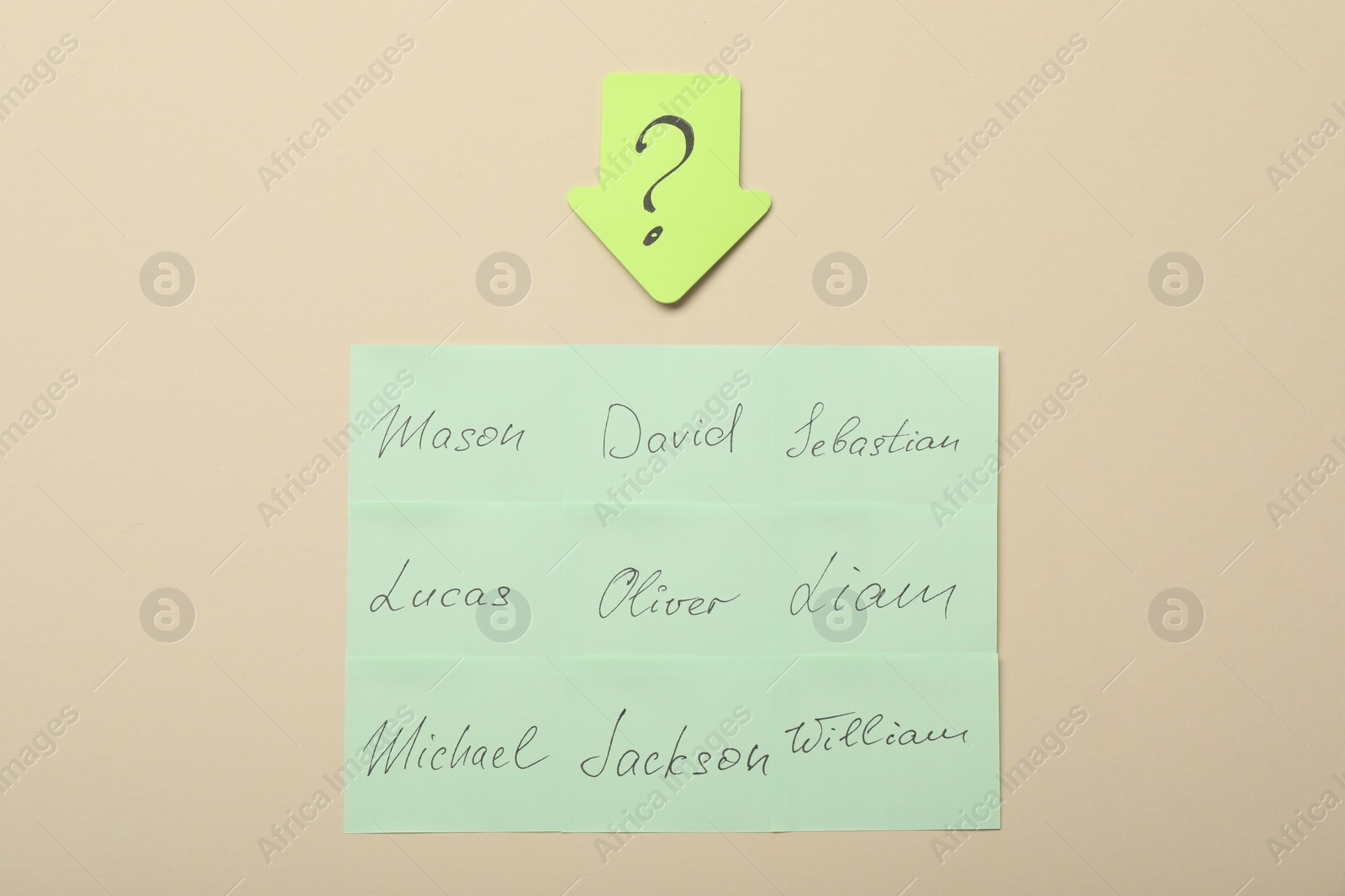 Photo of Choosing baby`s name. Paper stickers with different names and question mark on beige background, flat lay