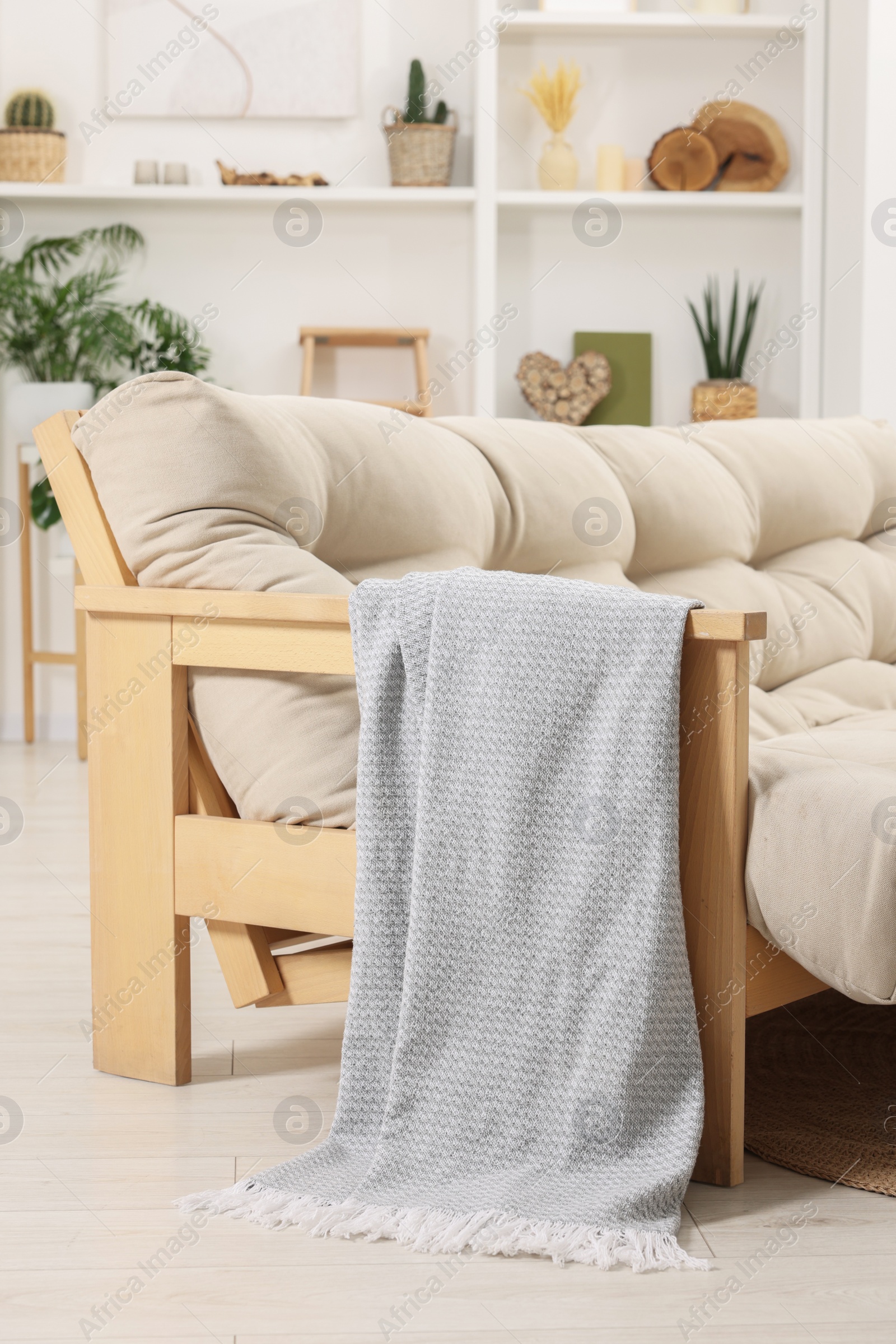 Photo of Comfortable sofa with grey blanket in living room