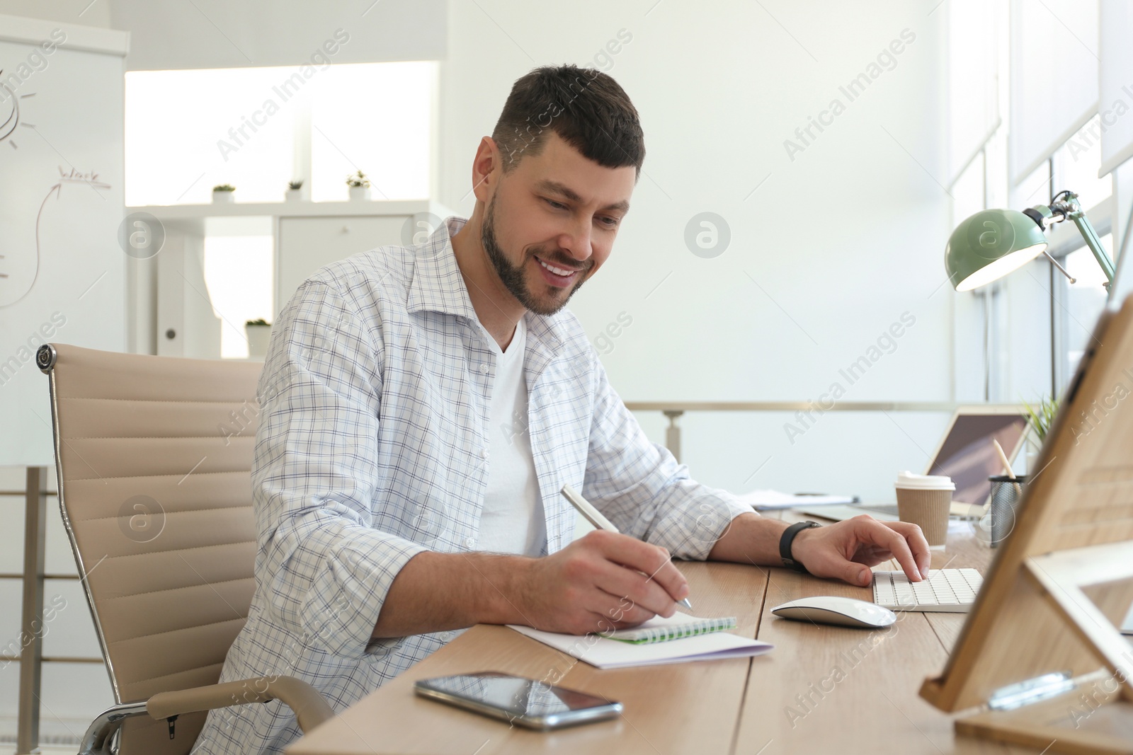 Photo of Freelancer working with computer at table indoors