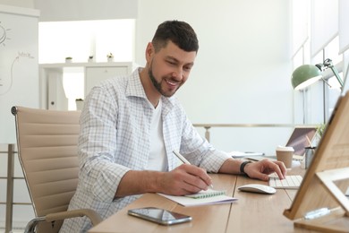Photo of Freelancer working with computer at table indoors