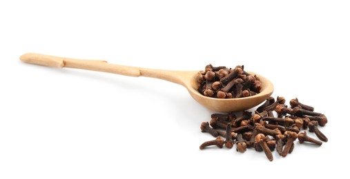 Pile of aromatic dry cloves and wooden spoon on white background